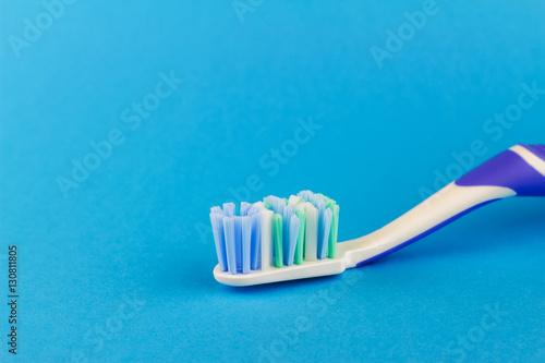 Macro photo of toothbrush isolated on blue background.