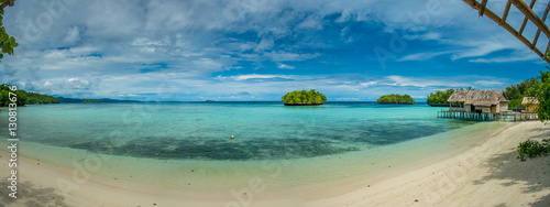 Fototapeta Naklejka Na Ścianę i Meble -  Beautiful Blue Lagoone with some Bamboo Huts, Kordiris Homestay, Palmtree in Front, Gam Island, West Papuan, Raja Ampat, Indonesia