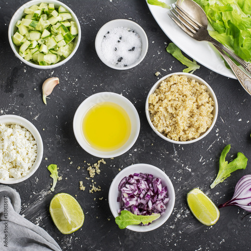 Ingredients for a light salad of quinoa, cucumber, cheese and sweet red onion with butter  lettuce on   gray background. Top view