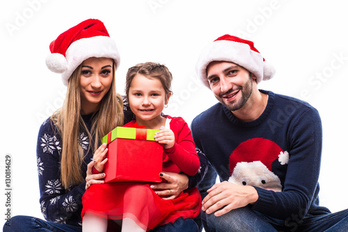 Young daughter get Christmas gift near mother and father on white background.