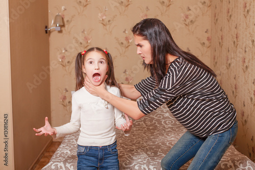 Mother trying to strangle her little daughter.