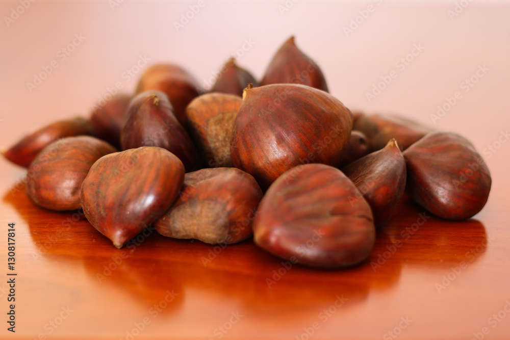 Raw chestnuts on wooden background Raw chestnuts on wooden background