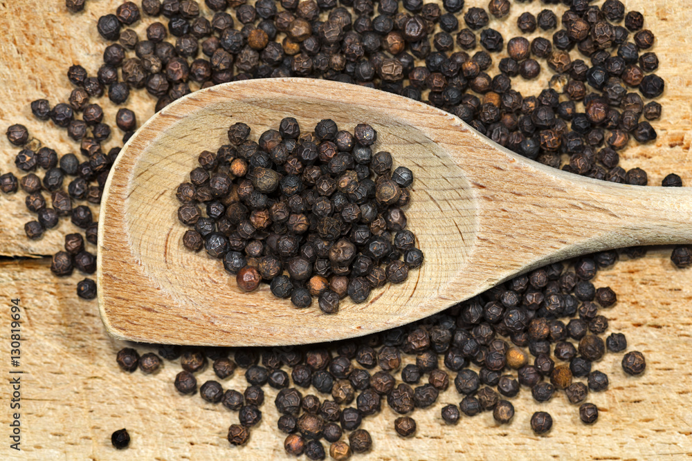 Peppercorns on a wooden spoon and cutting board Peppercorns on a wooden spoon and cutting board