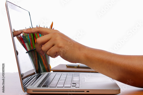 hand and her finger touch screen on monitor a laptop on a wooden table