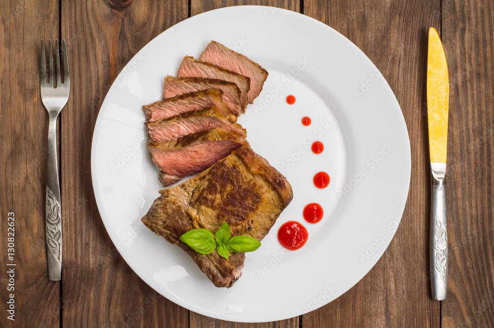 Rare Beef steak medium grilled with barbecue sauce. Wooden table. Top view. Close-up Rare Beef steak medium grilled with barbecue sauce. Wooden table. Top view. Close-up