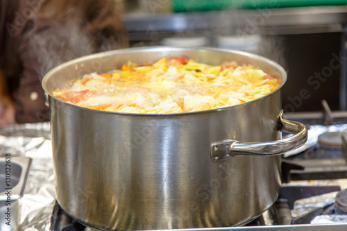 The soup is cooked in a large pot in the kitchen in the restaura