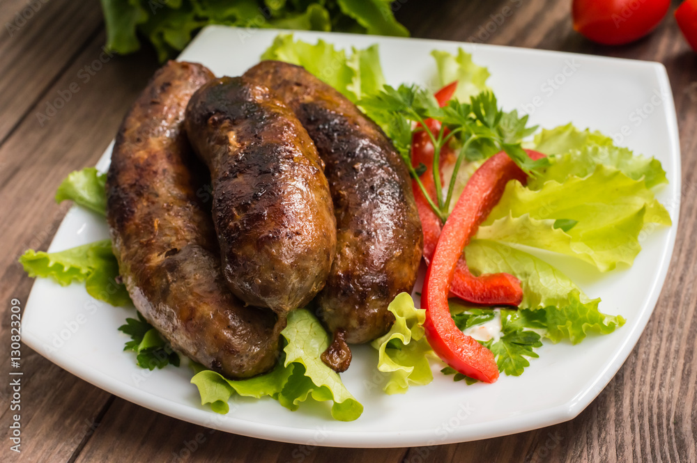 Bavarian sausages cooked on the grill. Wooden table Bavarian sausages cooked on the grill. Wooden table