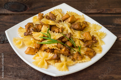 Farfalle with chicken and honey on a wooden table. Top view. Close-up