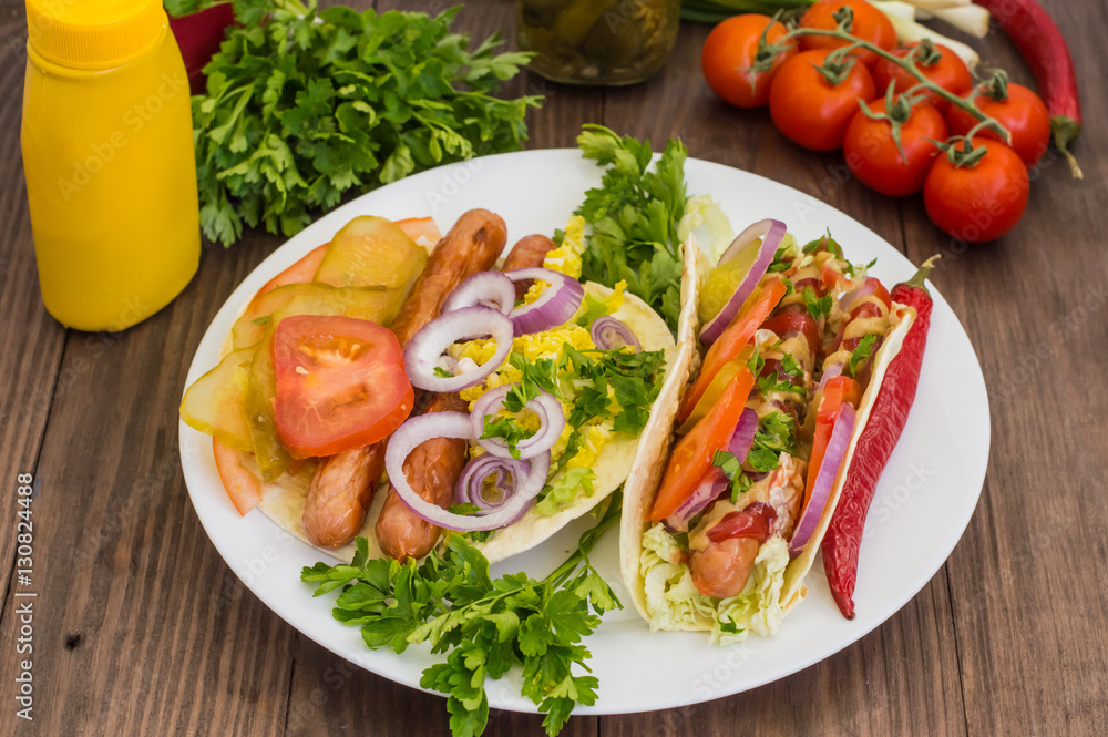 Ingredients for a picnic consisting of vegetables and sausages grilled on wooden rustic background, top view. Close-up Ingredients for a picnic consisting of vegetables and sausages grilled on wooden rustic background, top view. Close-up