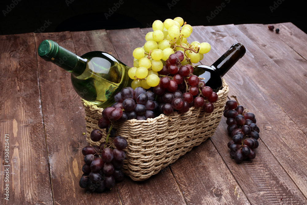 Obraz premium Bottle of white wine, grape and corks on wooden table 
