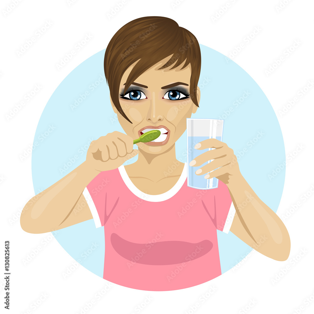young woman brushing teeth and holding glass of water young woman brushing teeth and holding glass of water