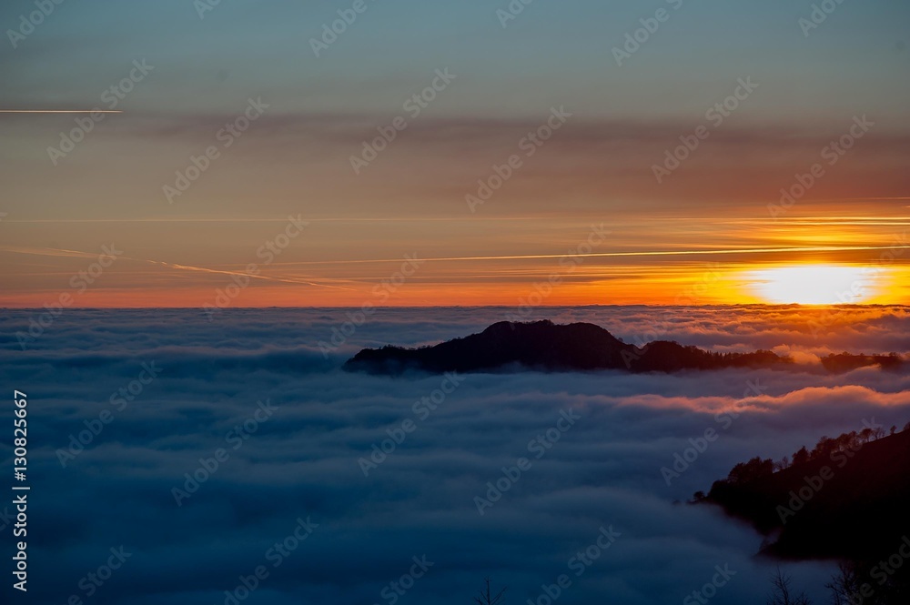 sunset in the mountains in a sea of fog