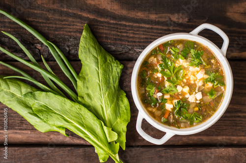 Green soup with eggs and ingredients for his cooking. Wooden background