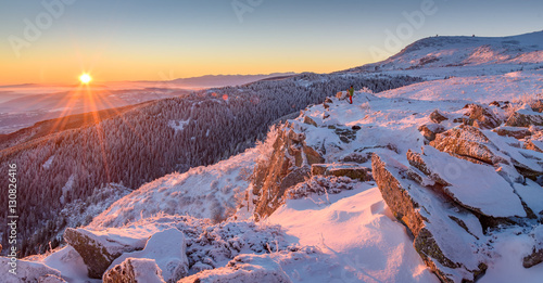 Beautiful frosty sunrise in the mountains - Vitosha, Bulgaria - the sun rising over the snowy frozen rocks
