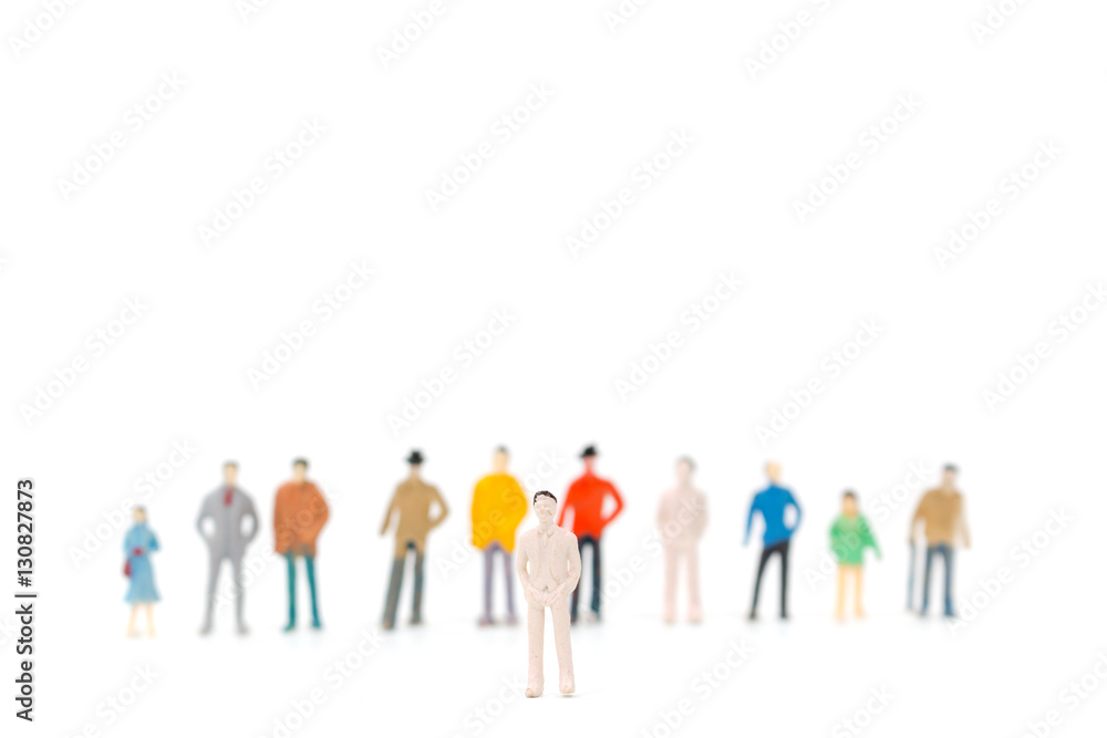 Group of miniature people standing on white background