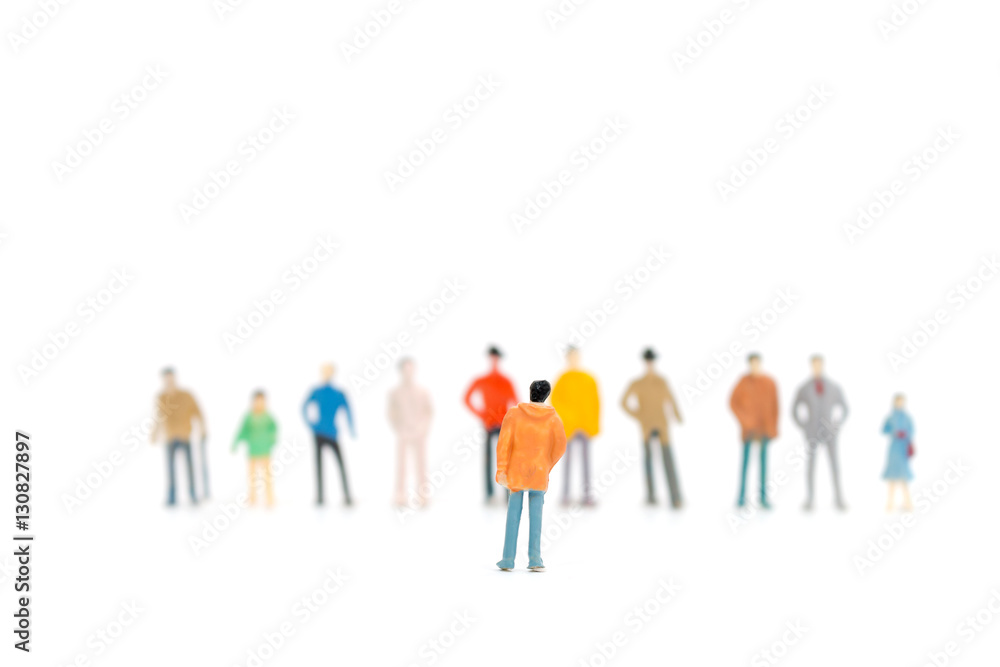 Group of miniature people standing on white background