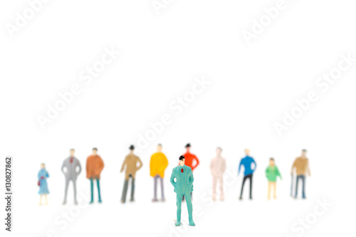 Group of miniature people standing on white background