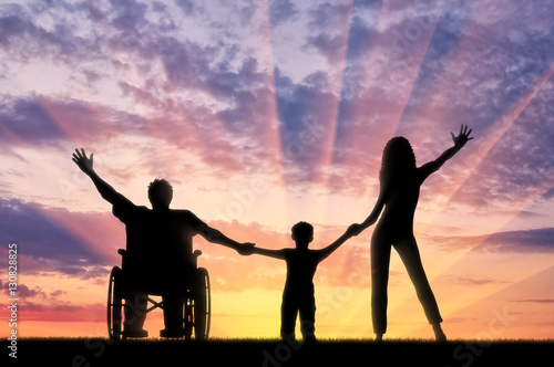 Disabled in wheelchair and happy family on sunset background