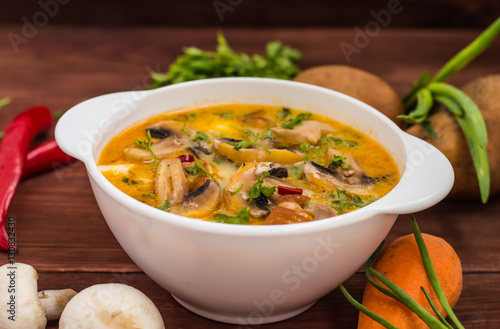 Delicious soup with smoked chicken, mushrooms, eggs and cream. Wooden background