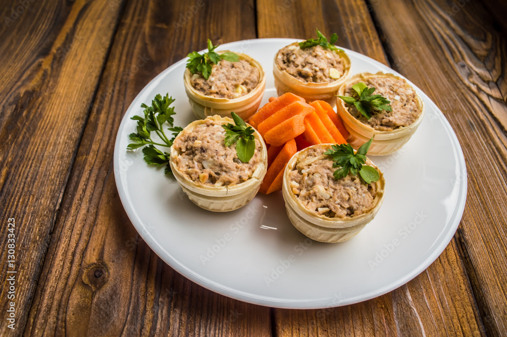 Tartlets with pate of fish and greens on a wooden old background. Top view. Close-up