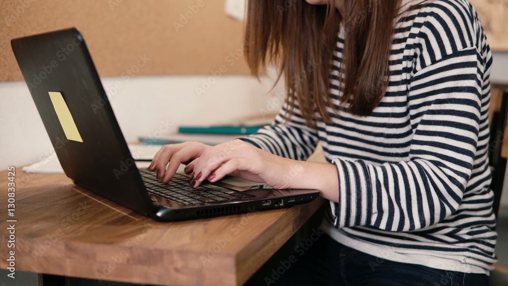 closeup of the hands of young attractive girl uses a laptop in the modern startup office closeup of the hands of young attractive girl uses a laptop in the modern startup office