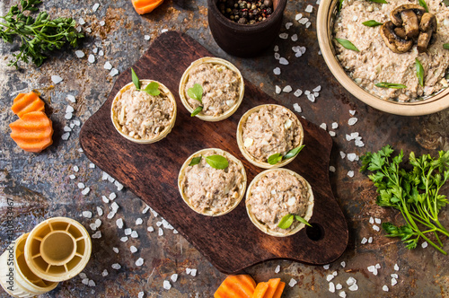 Tartlets with pate of fish and greens on a wooden old background. Top view. Close-up