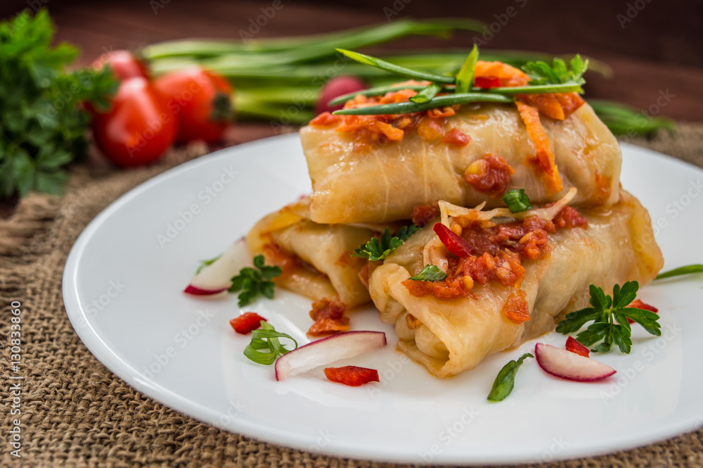 Cabbage rolls in tomato sauce. Wooden background. Close-up
