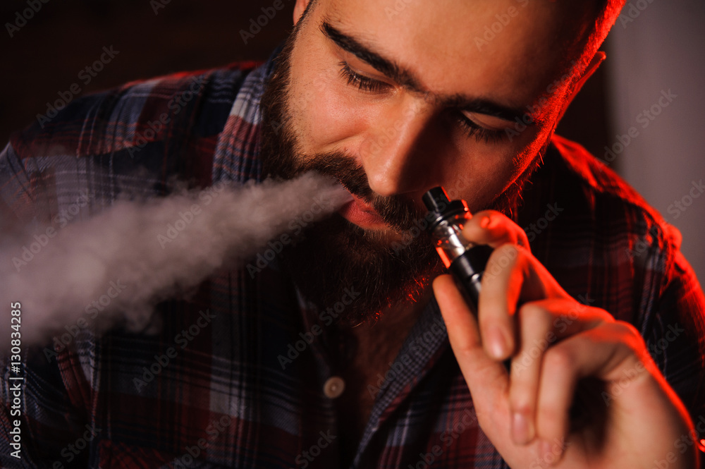Obraz premium Brutal man smoking electronic cigarette