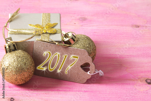 happy new year card with gift box and tag on pink wooden bakckground photo