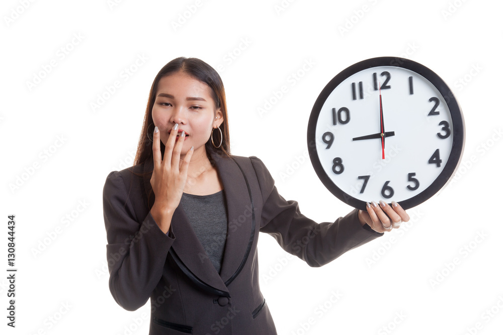 Sleepy young Asian business woman with a clock in the morning. Sleepy young Asian business woman with a clock in the morning.