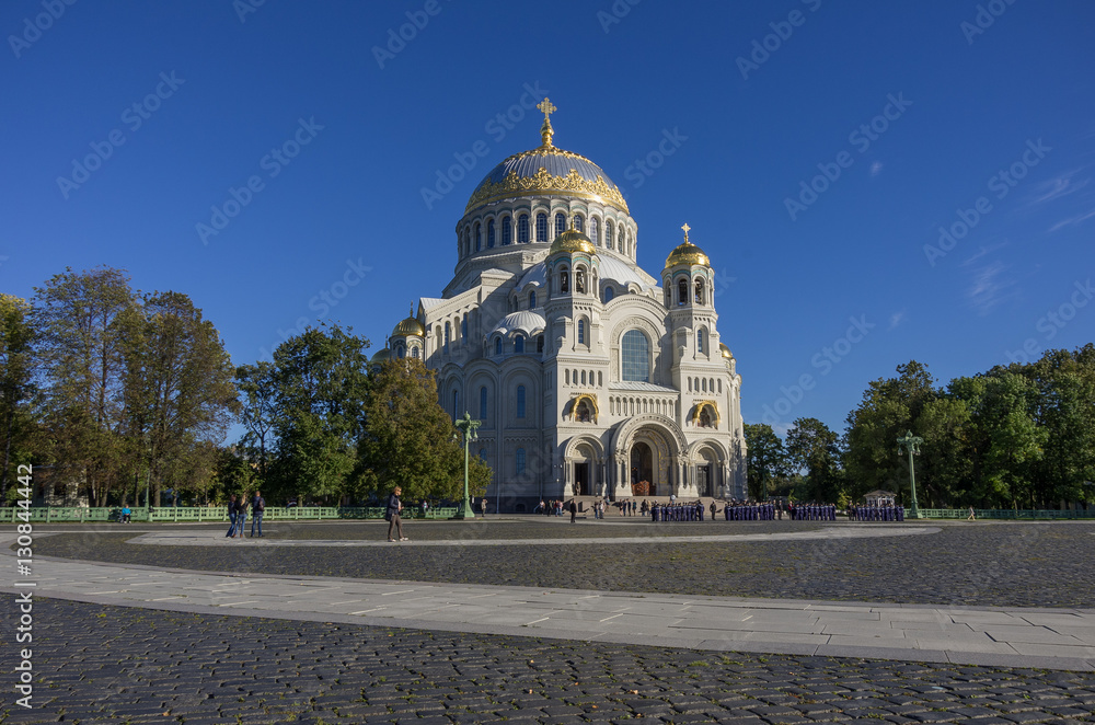 Naval Cathedral of St. Nicholas and the square with tourists and young naval cadets in Kronstadt at Sunny day. Russia