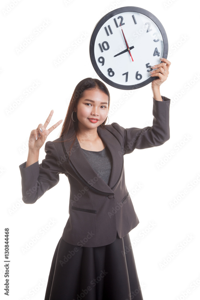 Young Asian business woman show victory sign with a clock. Young Asian business woman show victory sign with a clock.