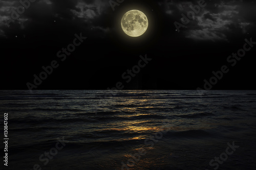 Beautiful magic blue night sky with clouds and full moon  stars  reflexion in water