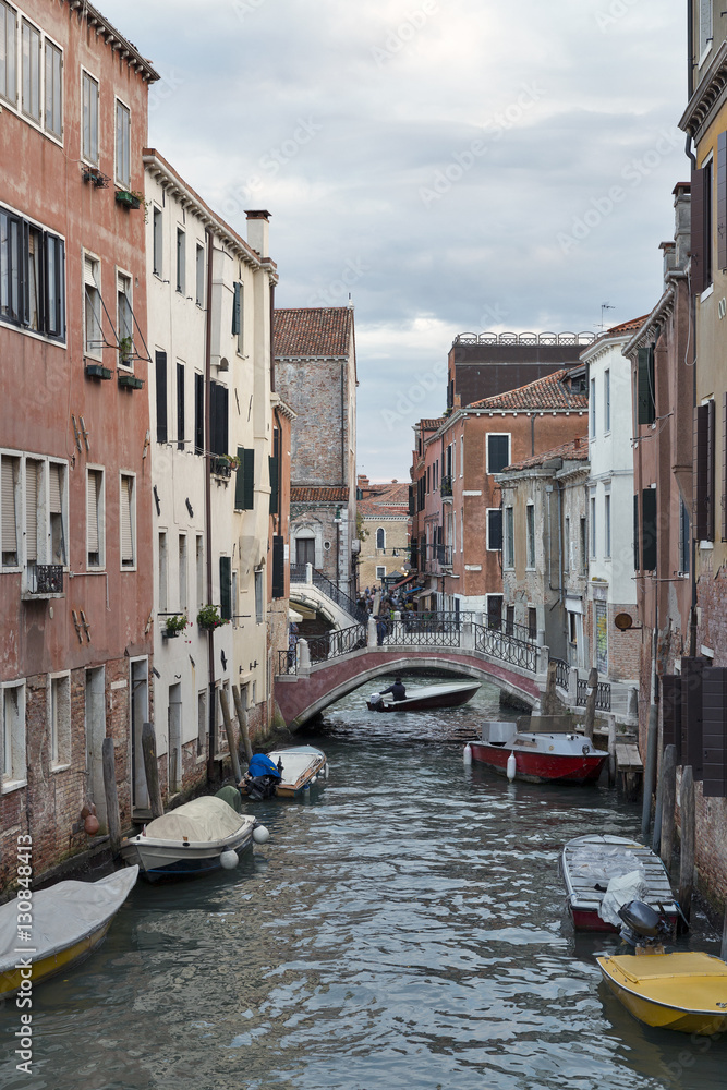 Venice cityscape, narrow water canal, bridge and traditional buildings.