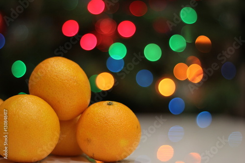 Bright yellow mandarins on the Christmas tree with garland