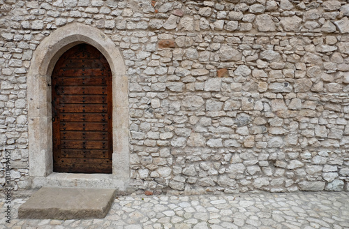wooden back door in white / gray stone wall