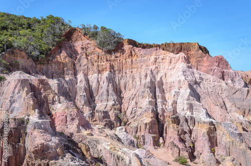 Canyon cliffs with many rocks sedimented by time, rocks with red and yellow colors. Cliffs of Coqueirinho beach, PB - Brazil.