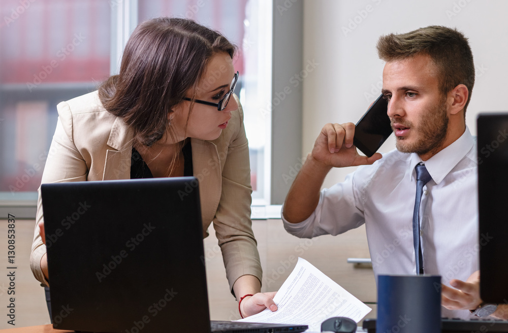 Businessman and businesswoman discussing work in office. Multitasking, stress, pressure. Businessman and businesswoman discussing work in office. Multitasking, stress, pressure.