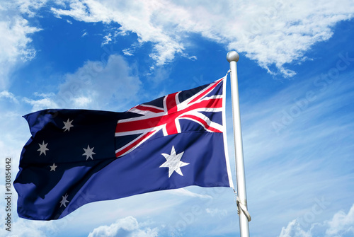 Australia flag waving in blue cloudy sky