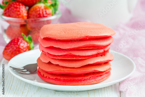 Stack of red velvet pancakes on white plate, horizontal