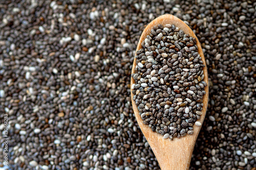 Close up chia seeds in wooden spoon on chia seeds background