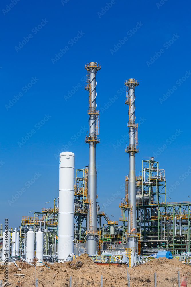 Fototapeta premium Refinery tower in petrochemical industrial plant with cloudy sky