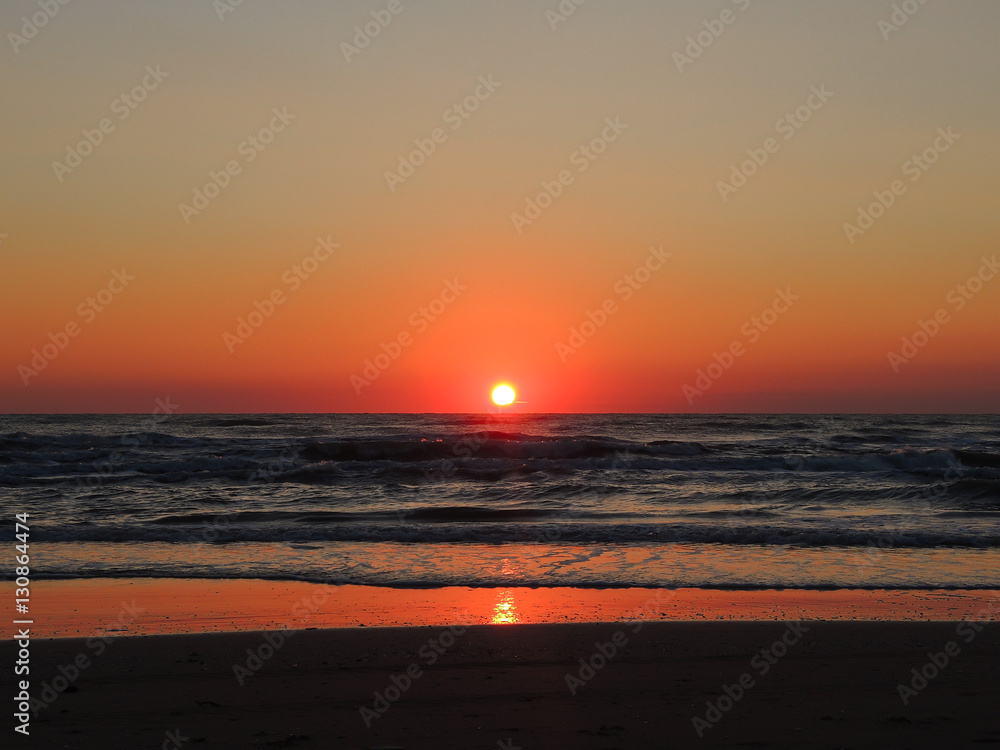 Fiery sunrise at Italian beach. Summer season. Emilia Romagna region. Adriatic sea. Italy