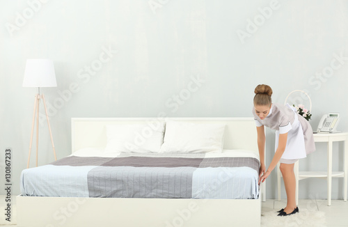 Chambermaid making bed in h...