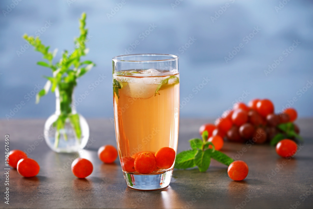 Fototapeta premium Refreshing summer drink with ice and mint, healthy beverage with cherry tomatoes and grapes on a table, this composition highlights a healthy lifestyle and fresh ingredients