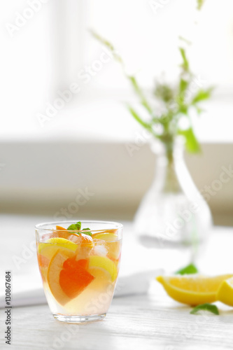 Citrus cocktail on table on blurred window background