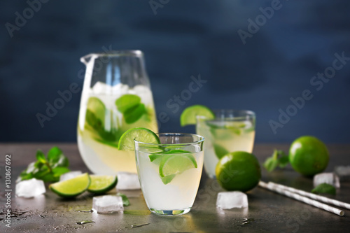 Fresh lime cocktail and ice cubes on table