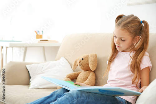 Cute girl with book at home