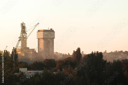 Artem-1 mine head frame in the forest at sunset