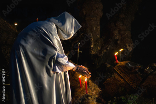 Man in priest clothes at dusk in forest